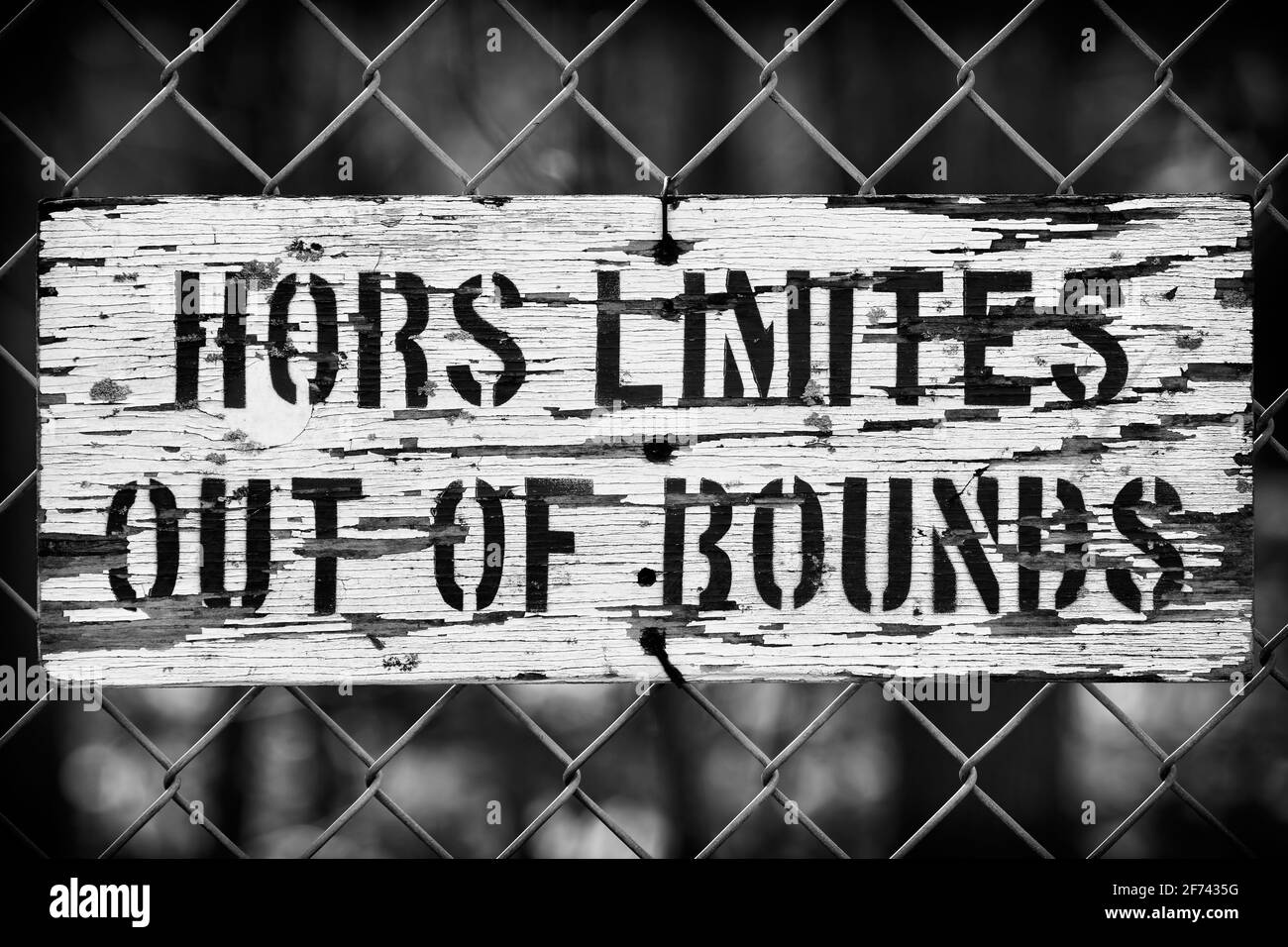 wooden black and white out of bounds, hors limites sign on fence Stock Photo