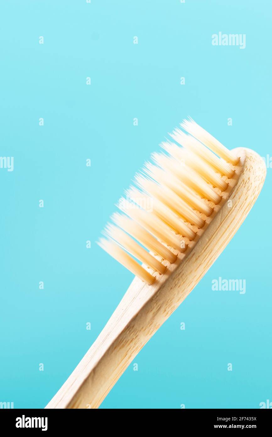 Bamboo toothbrush close up on blue background Stock Photo