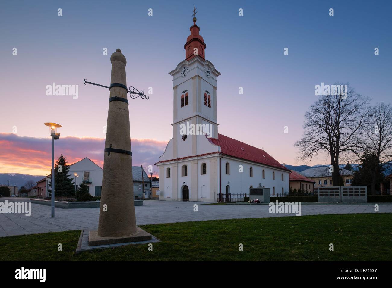 Church and whipping post in the main square of Sucany, Slovakia. Stock Photo