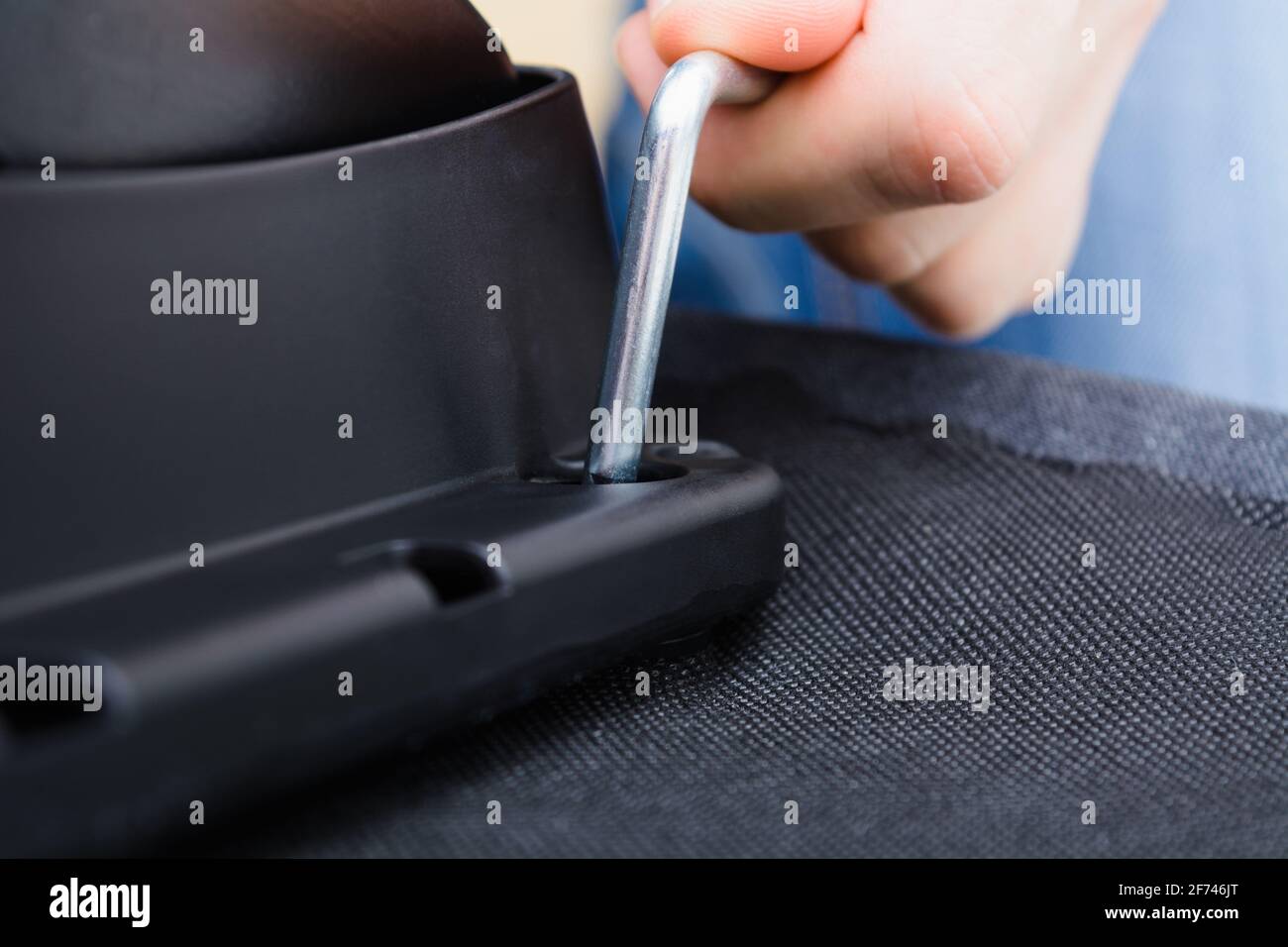 Caucasian man hands screw chair lifting mechanism. Assembling office