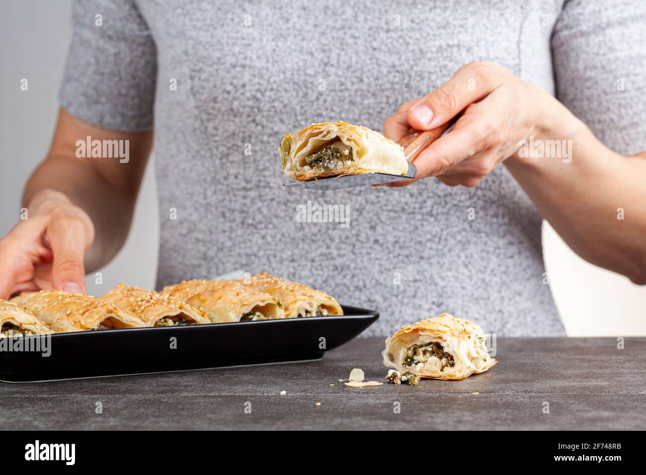 Traditional Turkish spinach pastry rolls ( Ispanakli borek ) served on a porcelain plate. Homemade recipe made using spinach and cheese fillings insid Stock Photo