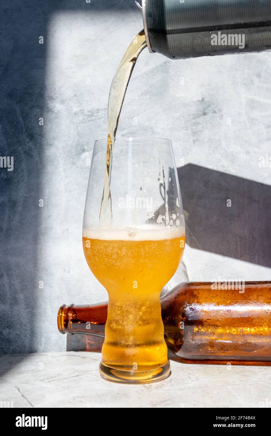 Serving beer, from a can to a crystal glass for IPA Stock Photo Alamy