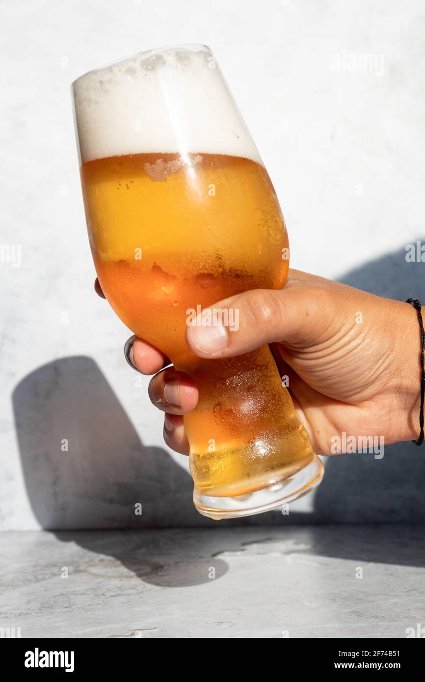 Hand Holding A Glass With Frothy Ipa Beer On A Hot Day Stock Photo Alamy