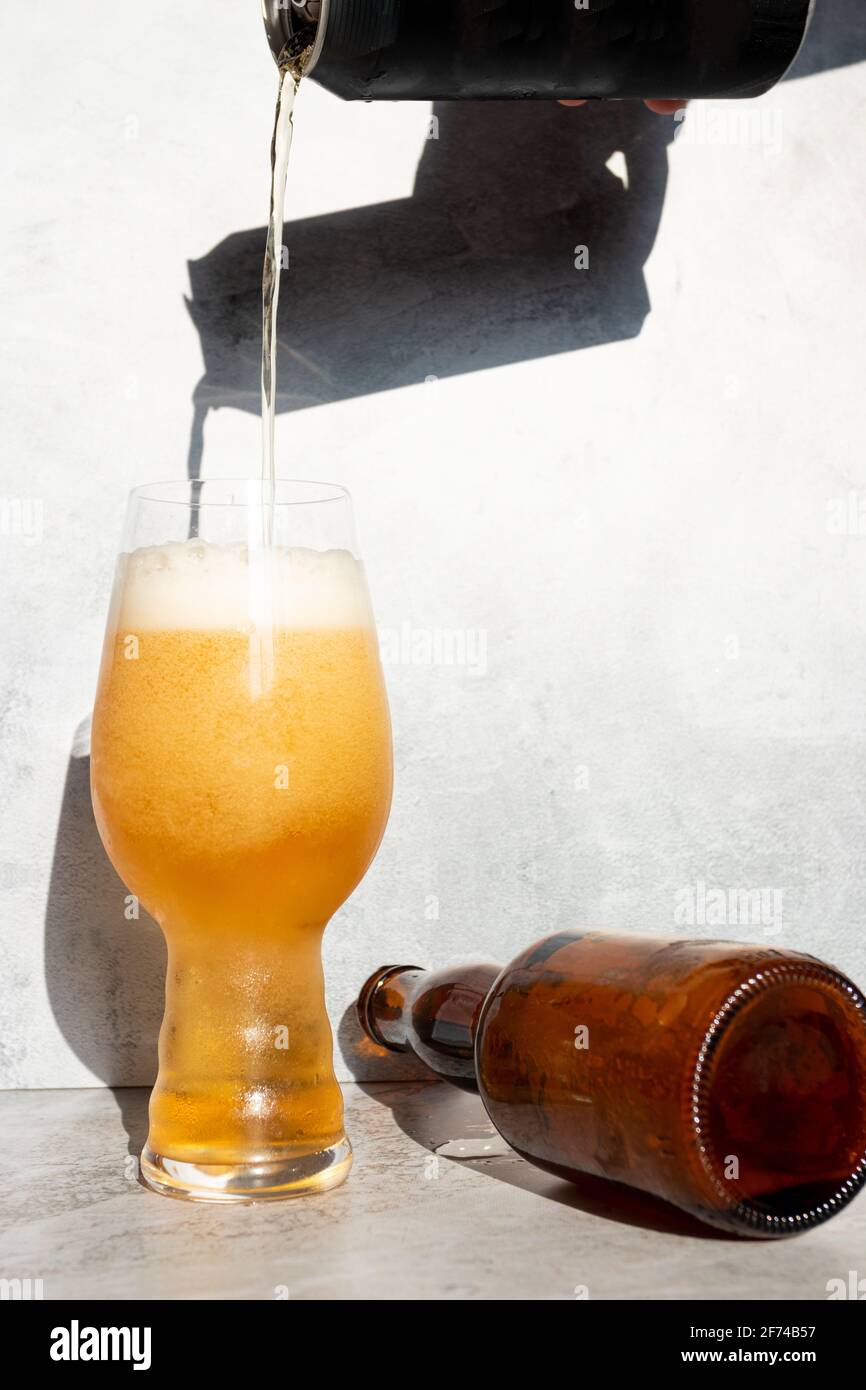 Serving beer, from a can to a crystal glass for IPA Stock Photo