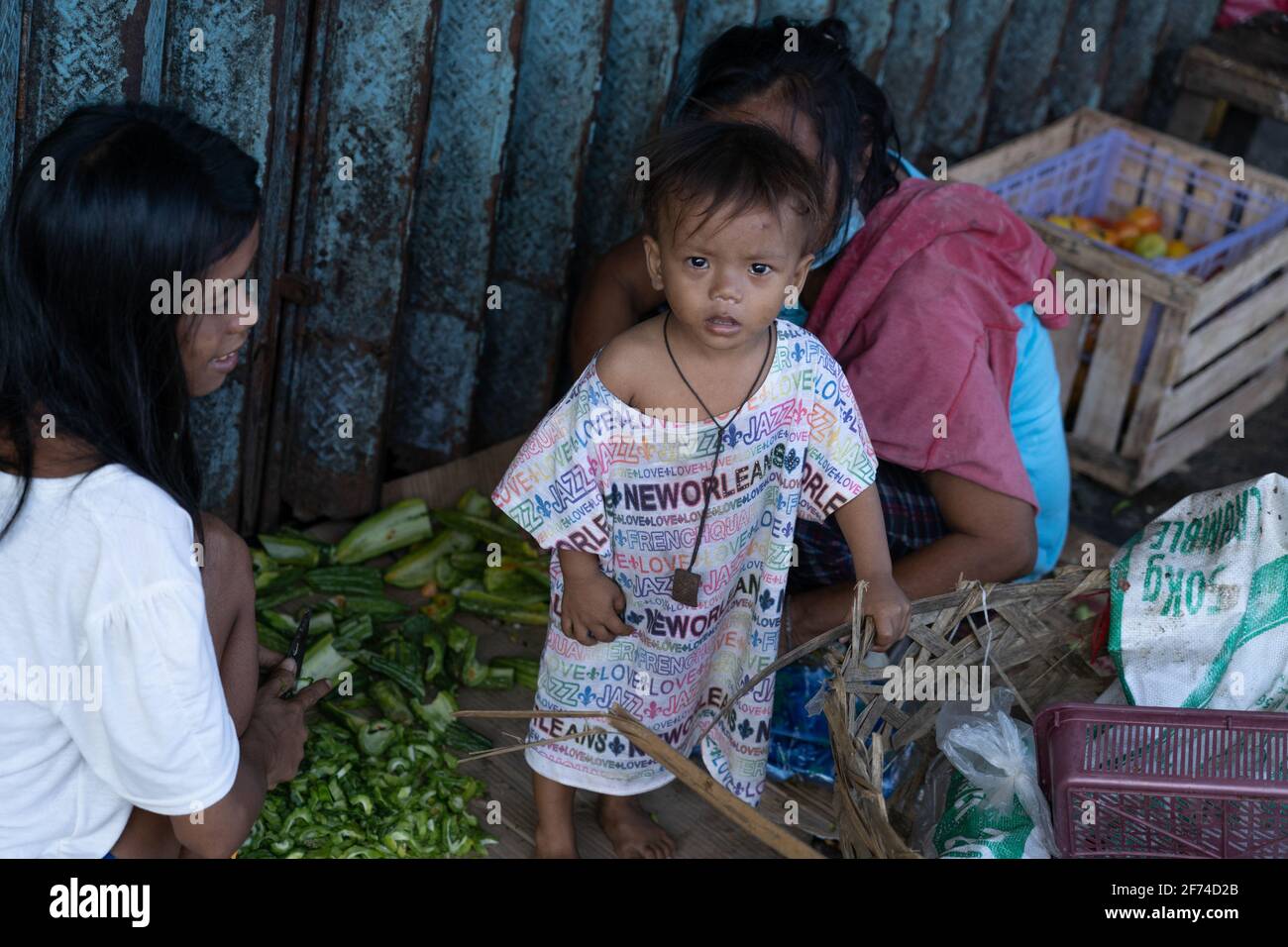 A young child in a poor area of Cebu City, Philippines looks up at the camera as the picture is taken Stock Photo
