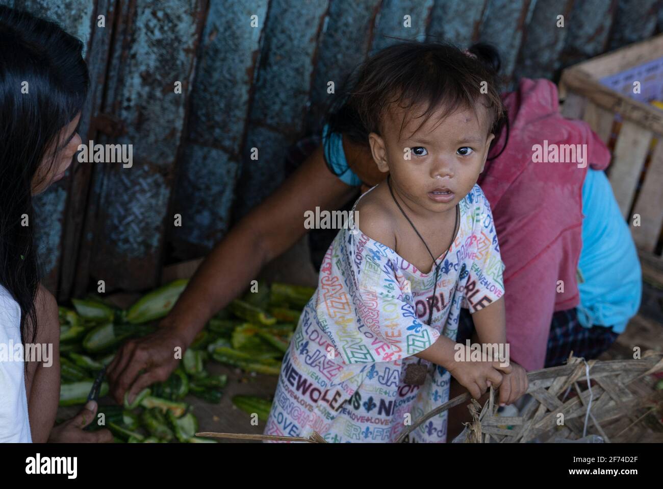 A young child in a poor area of Cebu City, Philippines looks up at the camera as the picture is taken Stock Photo