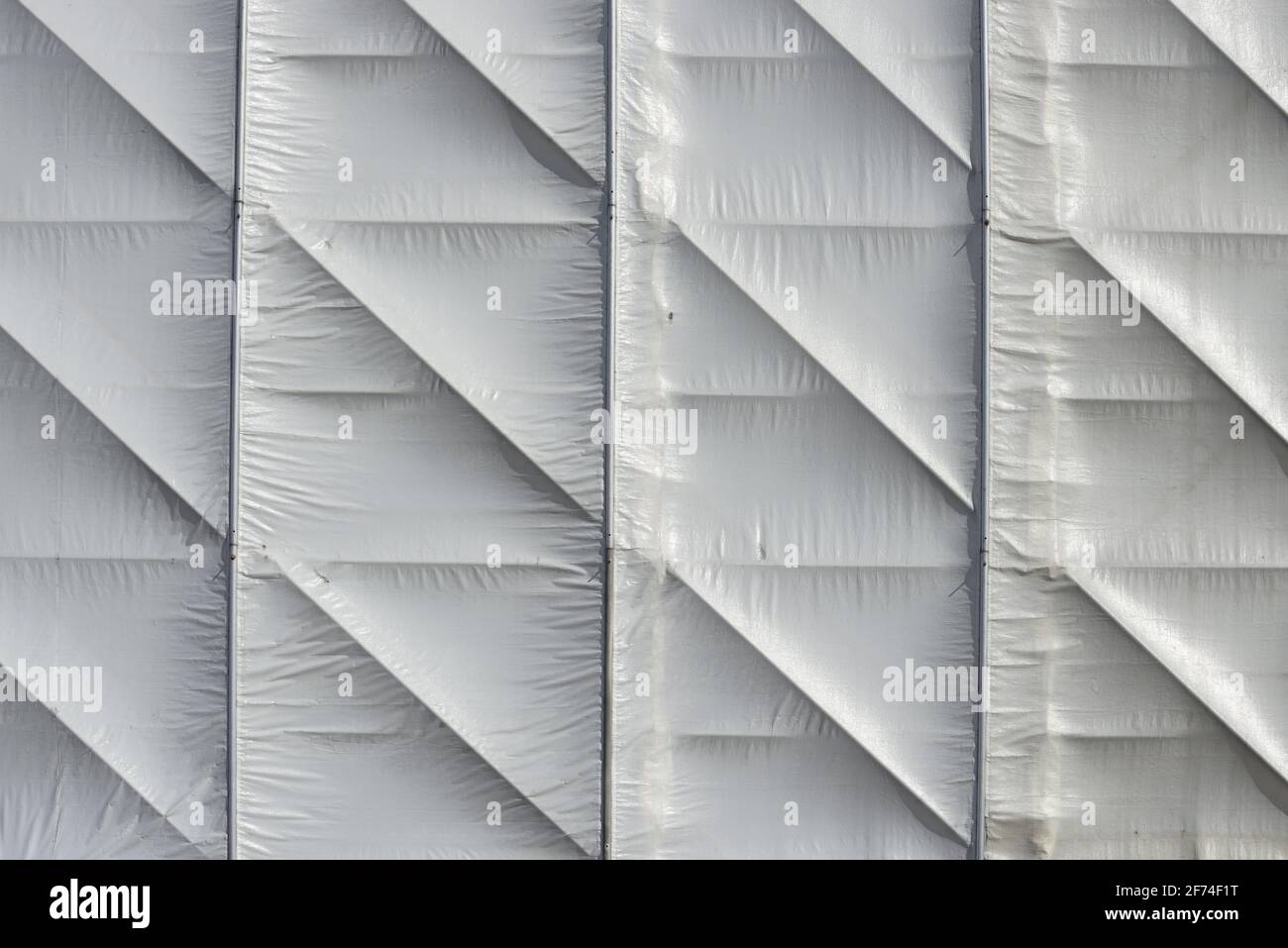 white synthetic material tarpaulin sheet, covering an interior wooden armature Stock Photo