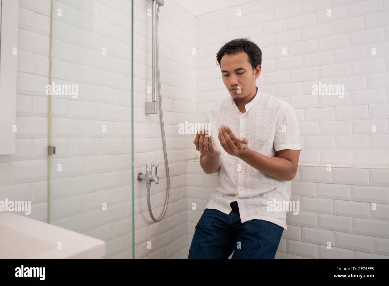 Muslim man praying after perform ablution (wudhu) at the bathroom Stock