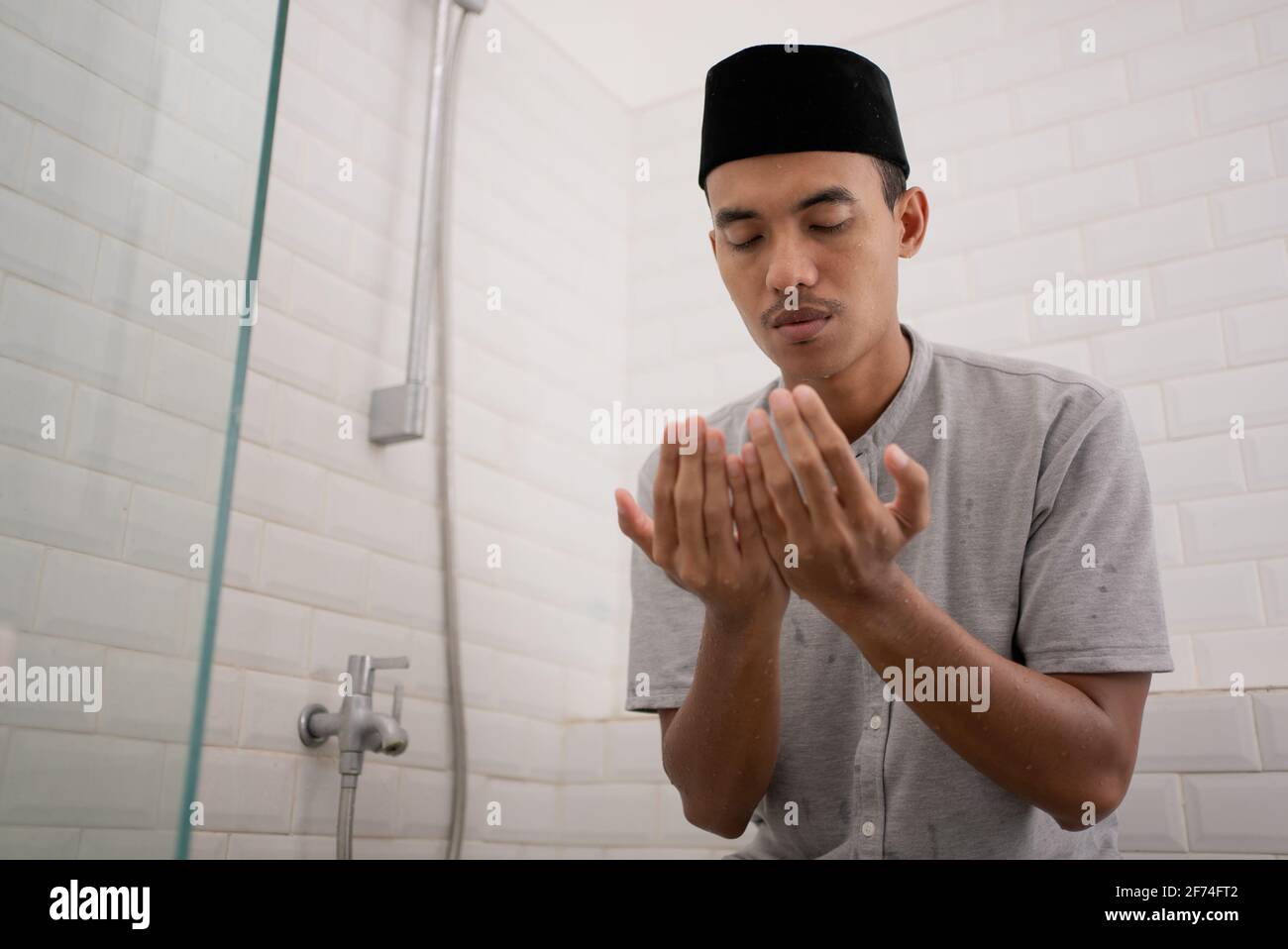 Muslim man praying after perform ablution (wudhu) at the bathroom Stock