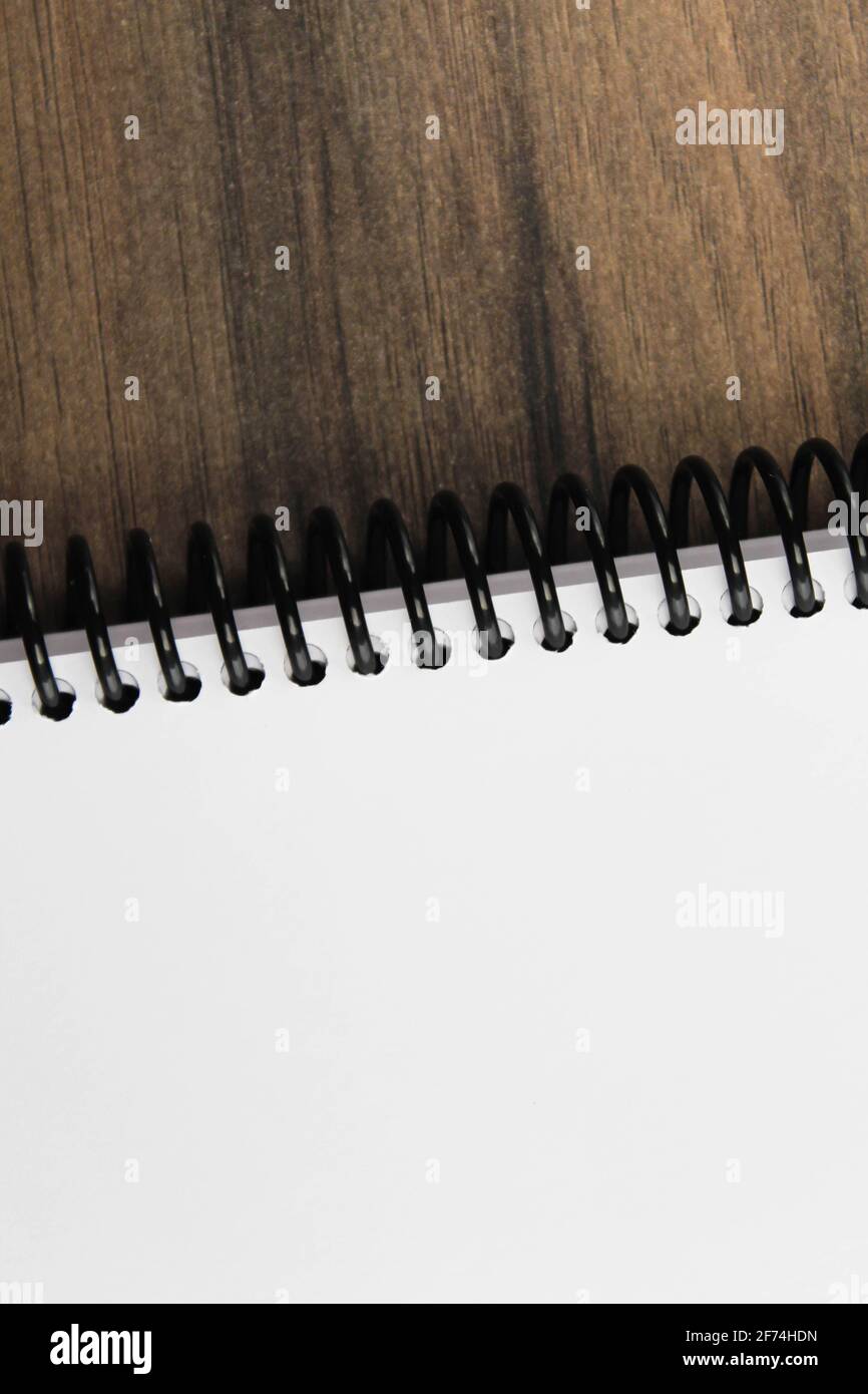 Spiral notepad paper on the wooden background. Vertical and space for text Stock Photo