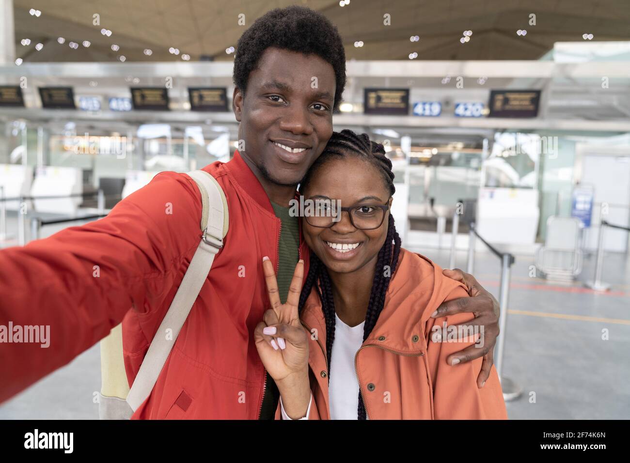 Happy African American couple taking selfie at airport terminal, ready for travel. Back to normality Stock Photo