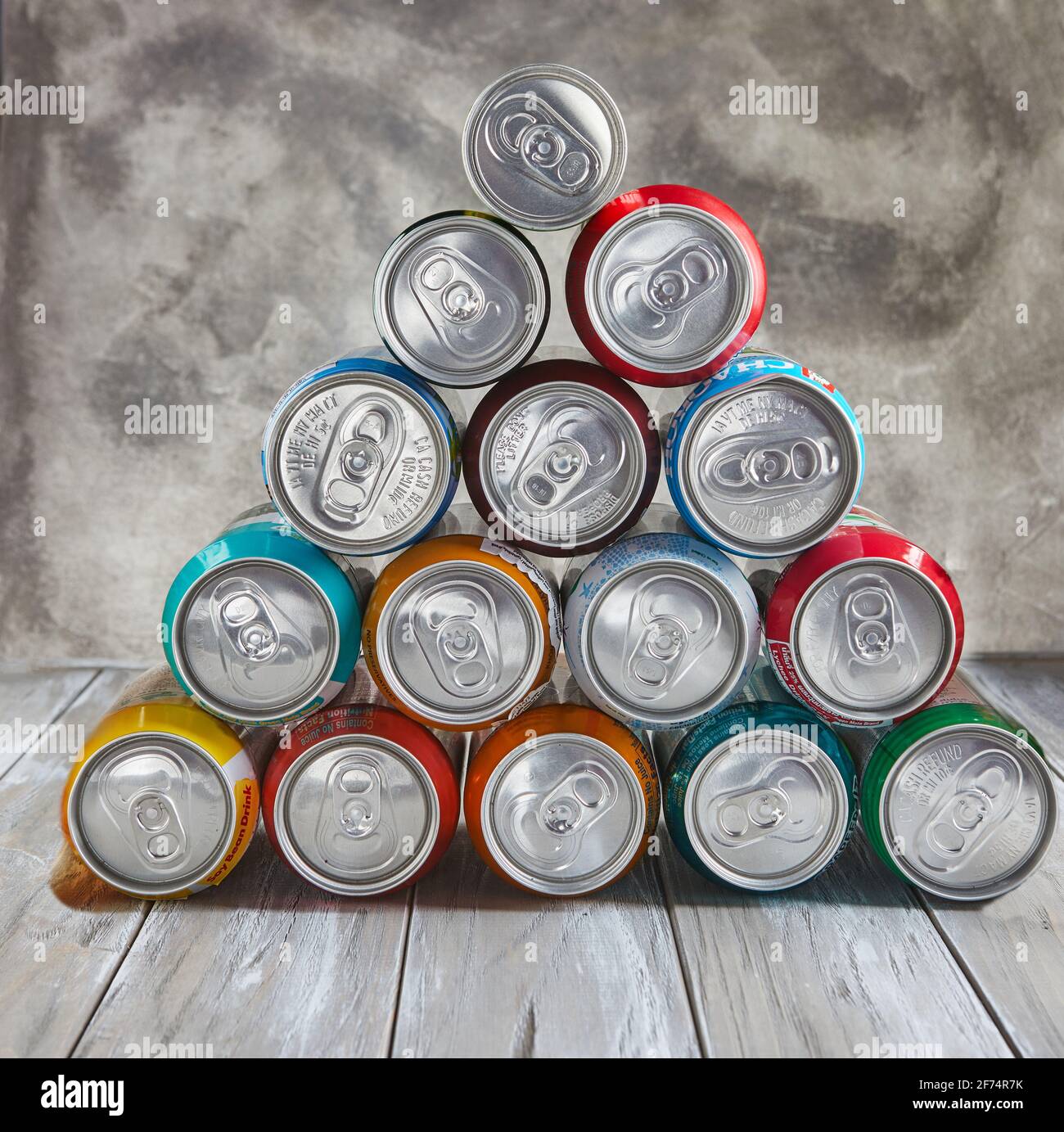 Drinks in cans stacked in a pyramid on the table. Stock Photo