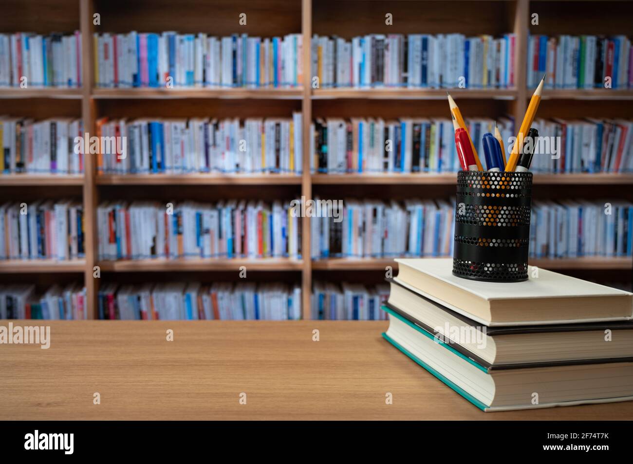 Blurred bookshelves and books on the desk. Education concept. Stock Photo