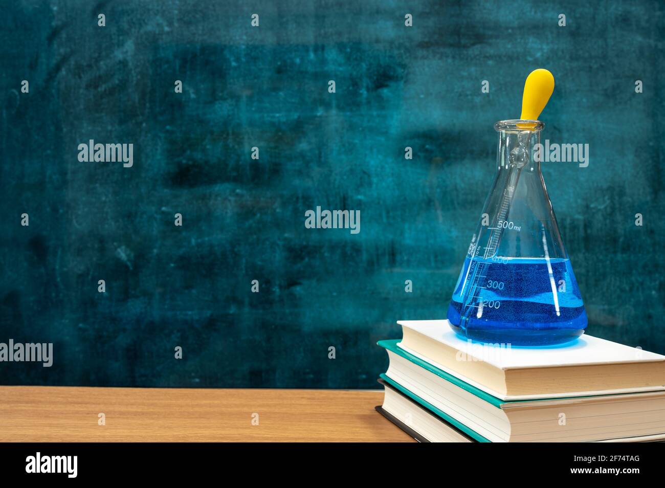 Books and scientific experiment tools on the desk. Empty blackboard