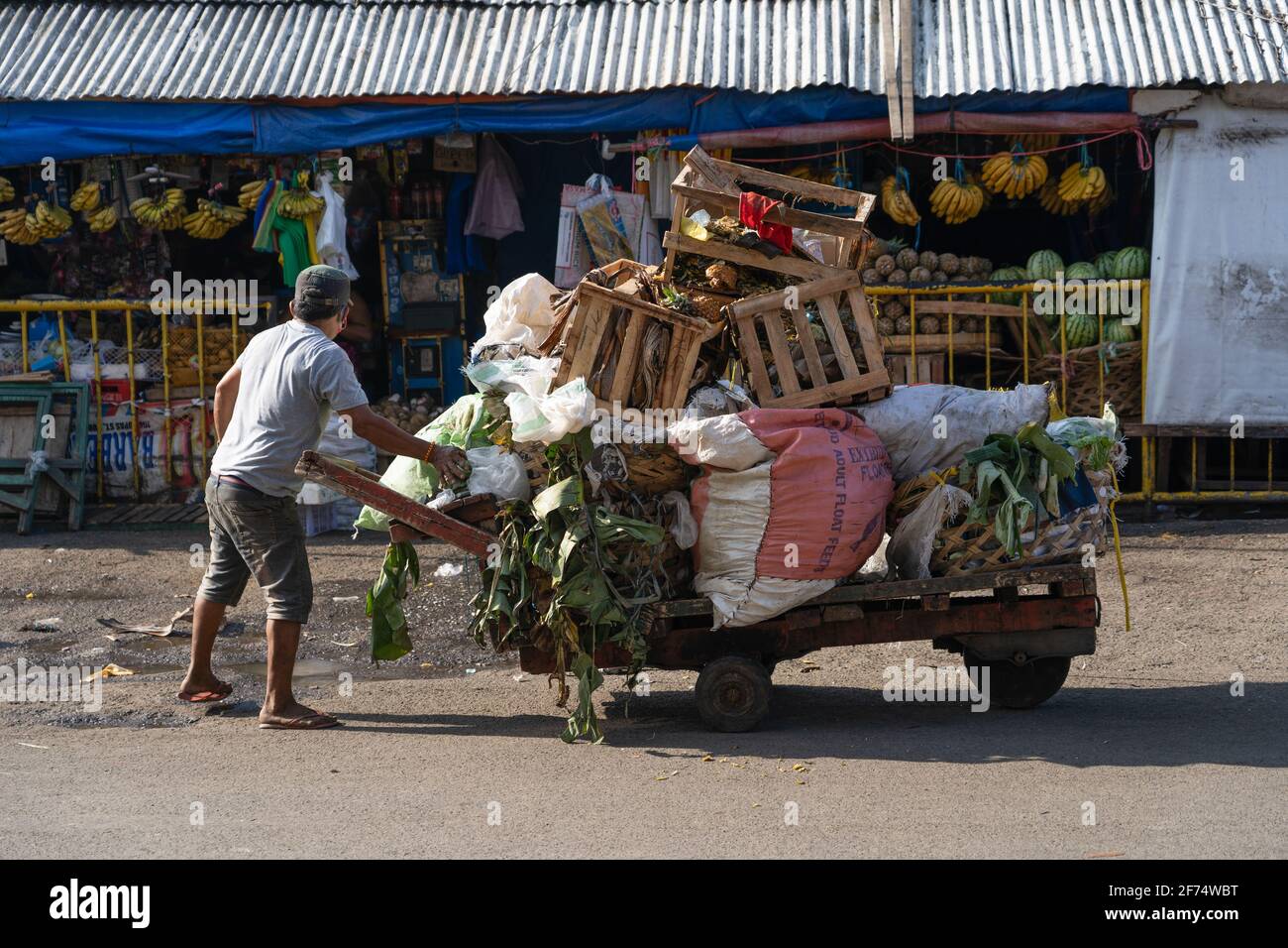 A man collecting market trash using a wooden cart, Cebu City, Philippines Stock Photo