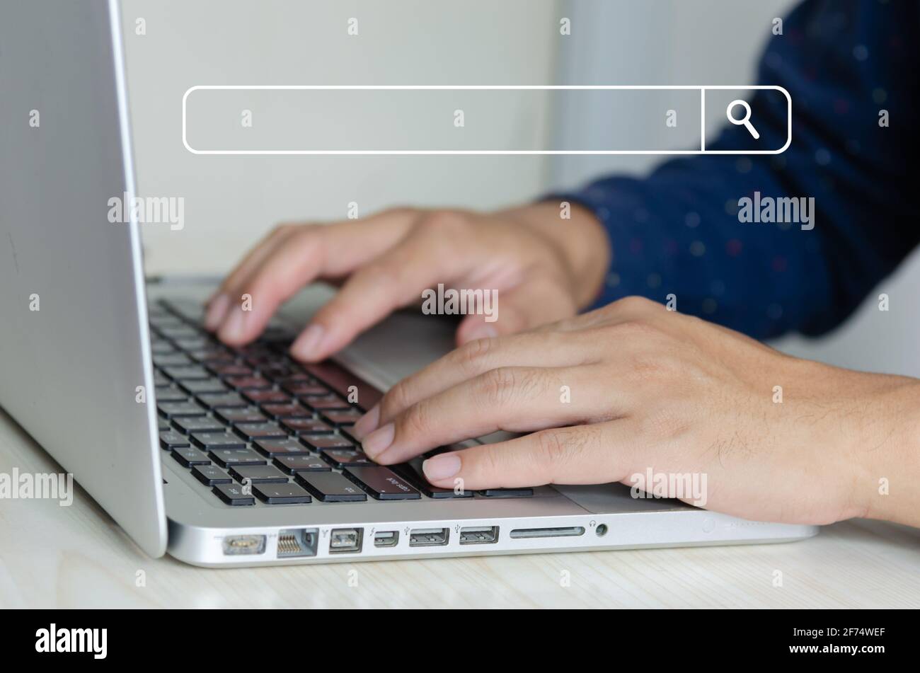 business man hand using a laptop keyboard is searching for information on the internet, social networks. Stock Photo