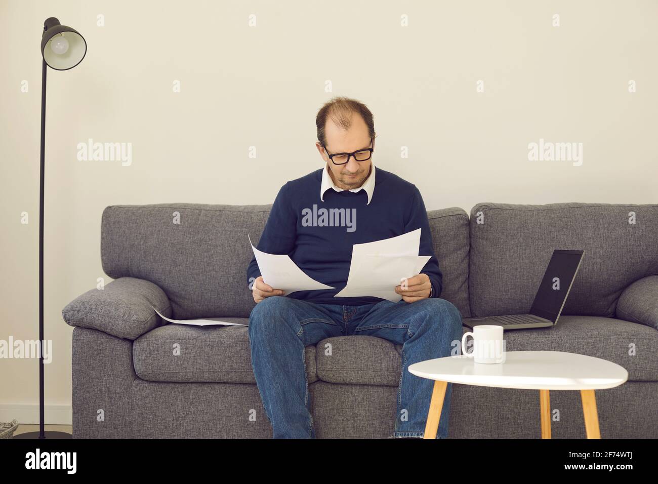 Mature businessman freelancer working with paper documents in home office Stock Photo