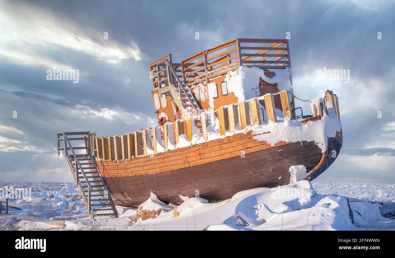 A wooden boat out of the water and turned into a public tourist attraction on the Hudson Bay shore in Churchill, Manitoba, Canada. Stock Photo