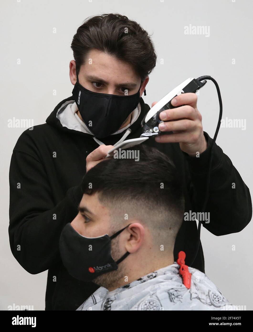 Barber Tony Mann trims Max Mann's hair at Tony Mann's Barber Shop in