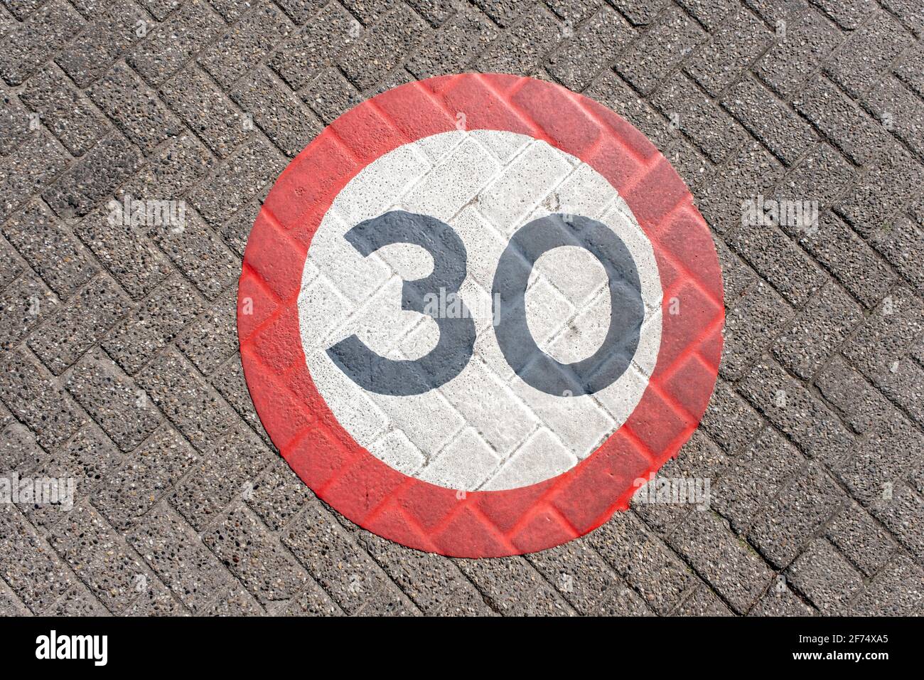 A traffic sign of 30km/h speed limit zone sign on a street. Stock Photo