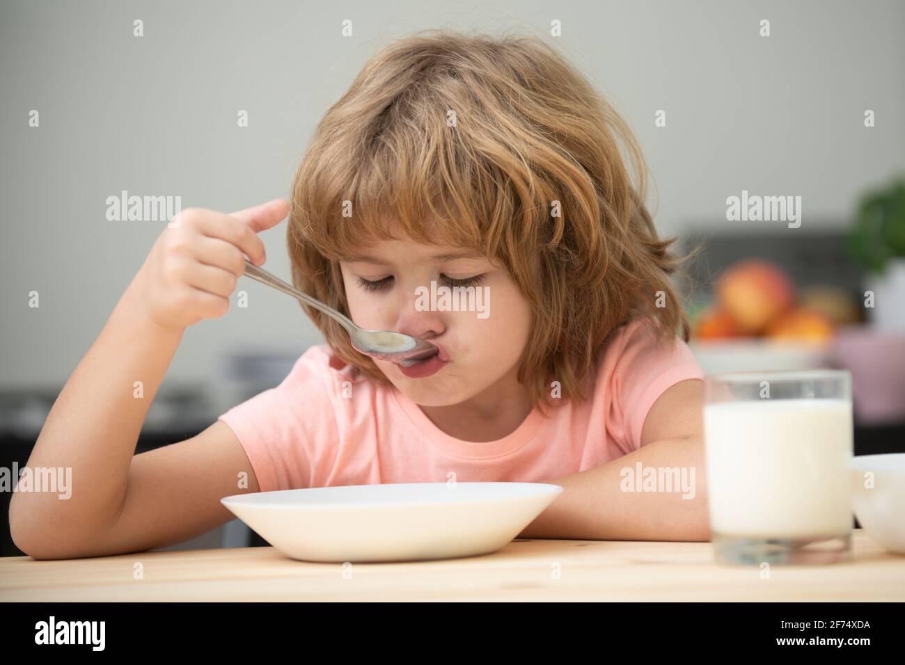 Child eating healthy food. Cute little boy having soup for lunch. Stock Photo