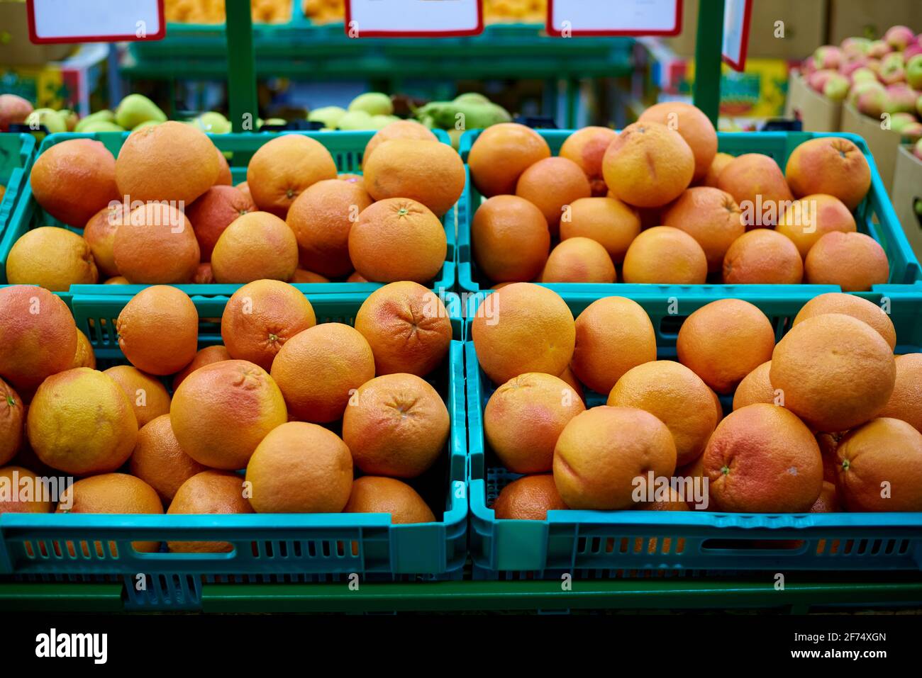 Boxes of grapefruit against fruits on the shelves in the supermarket