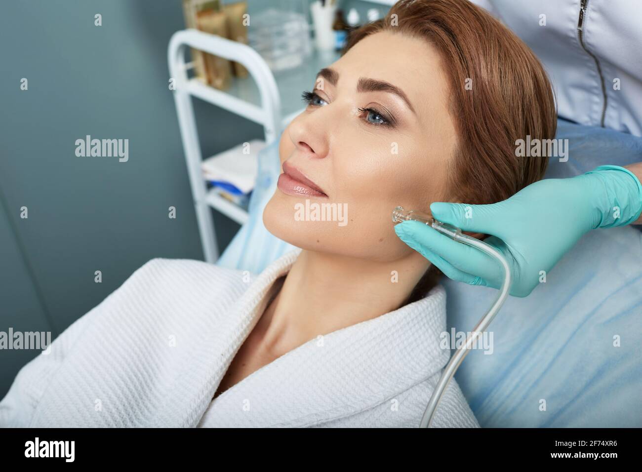 Facial ozone therapy for woman's face rejuvenation at a beauty salon. Oxygen treatment for skin Stock Photo