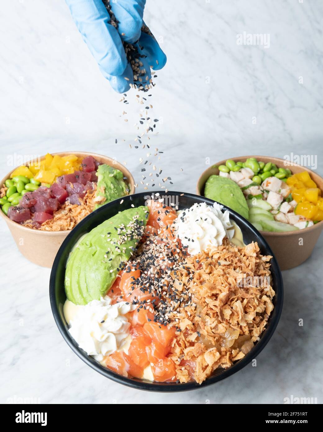 Crop chef decorating bowl with tasty poke dish served on marble table Stock Photo - Alamy