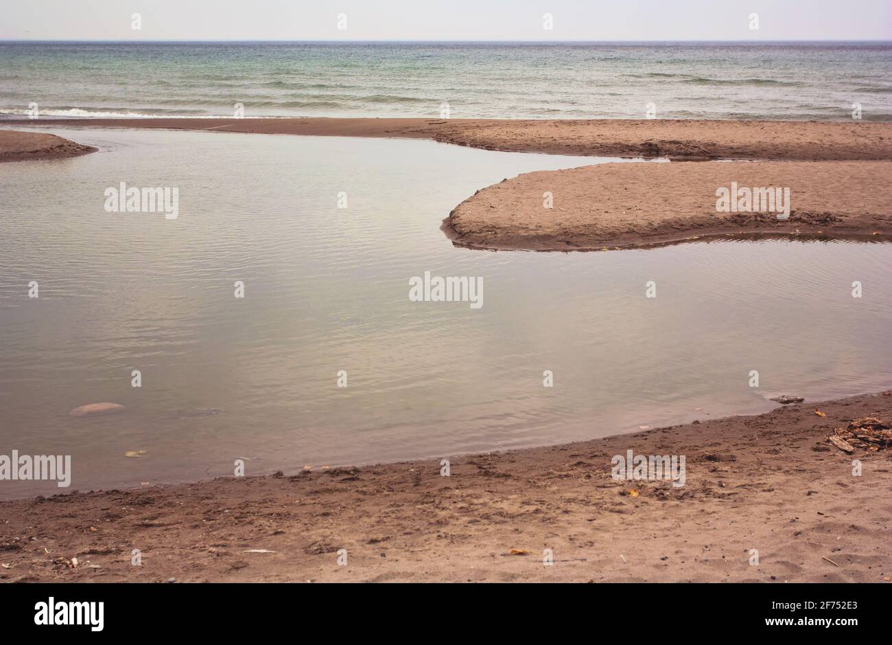Calm waters on a beach under a cloudy sky in Toronto, Ontario, Canada. Stock Photo
