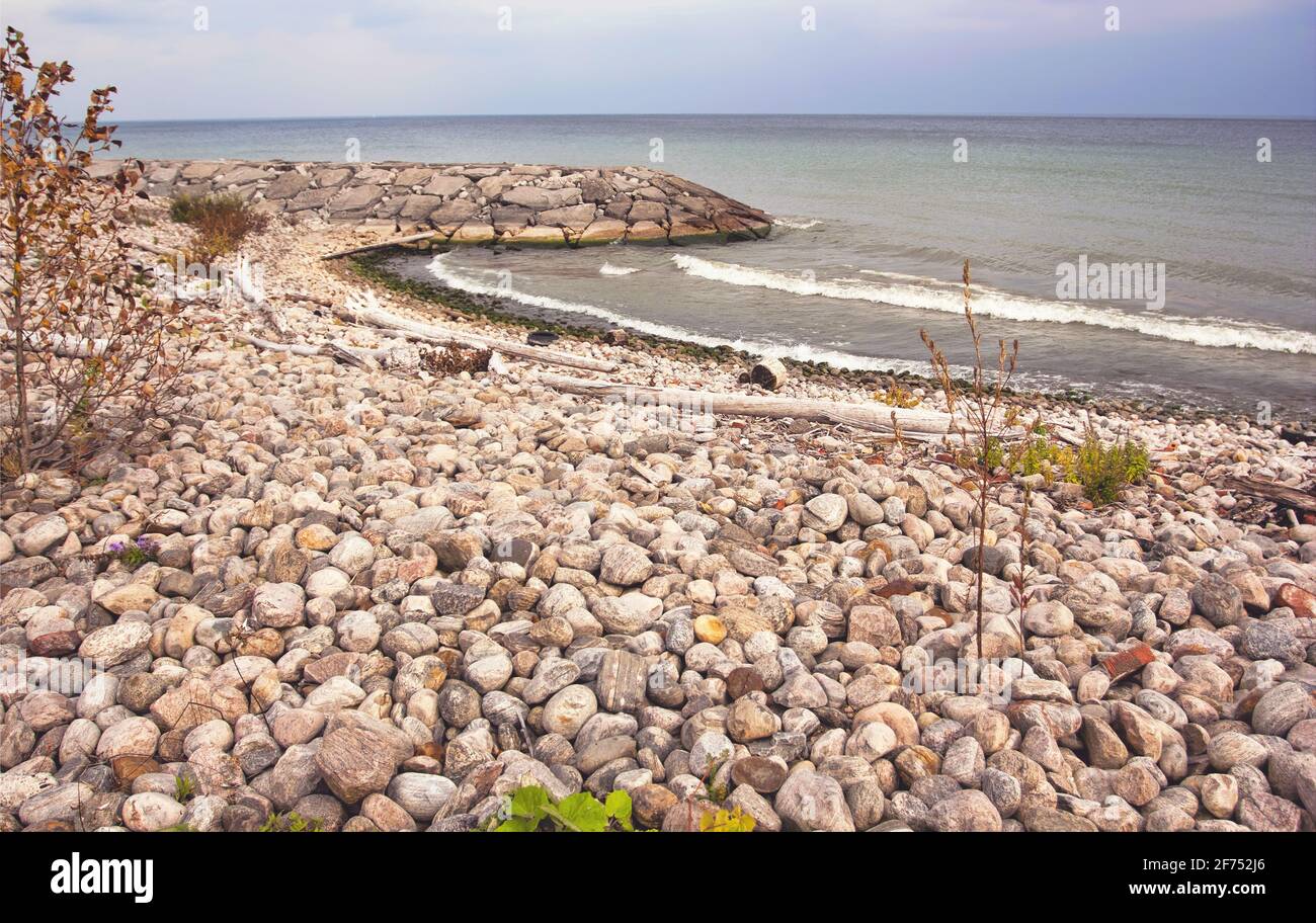 A beach landscape covered in various stones and rocks on a cloudy day in Toronto, Ontario, Canada. Stock Photo