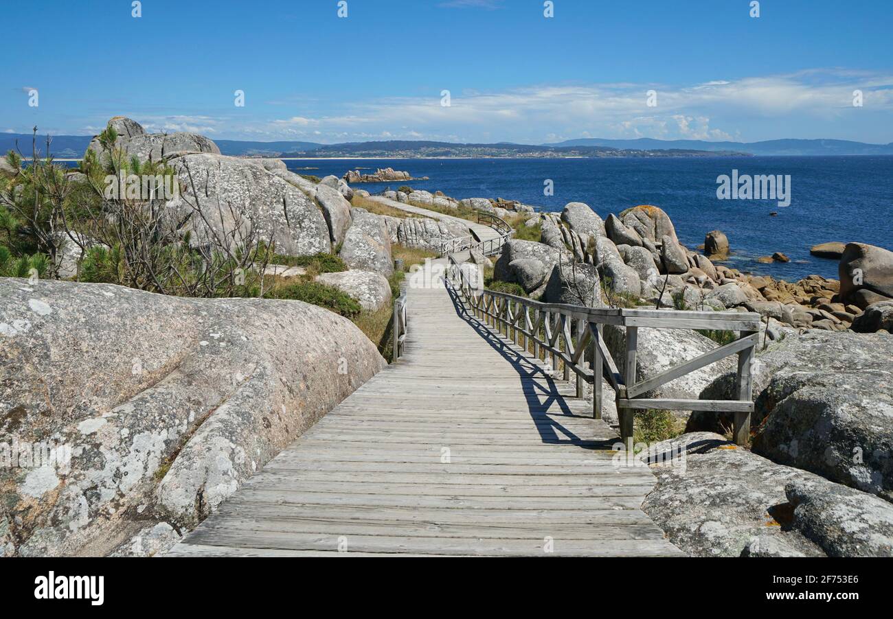 Spain, Galicia, wooden footpath along the coast with granite rocks, Atlantic ocean, province of Pontevedra, San Vicente do Grove Stock Photo