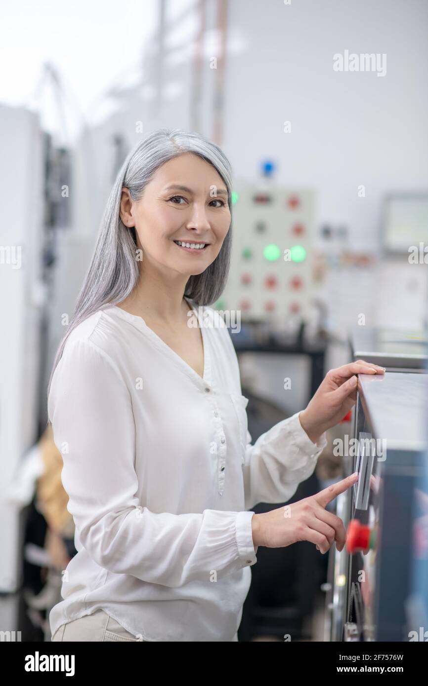 Contented woman near control panel of washing machine Stock Photo