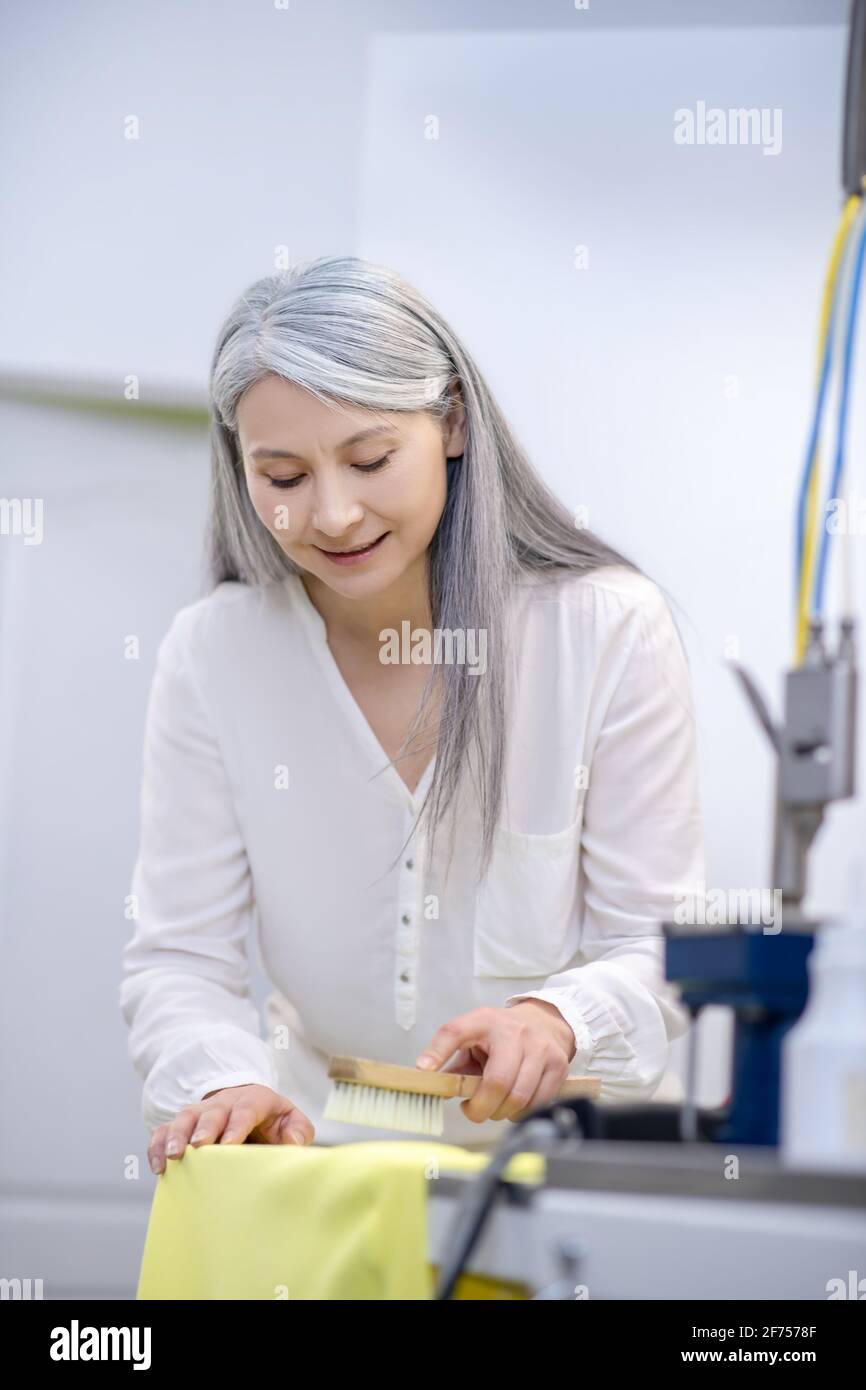 Woman in good mood removing stain from fabric Stock Photo