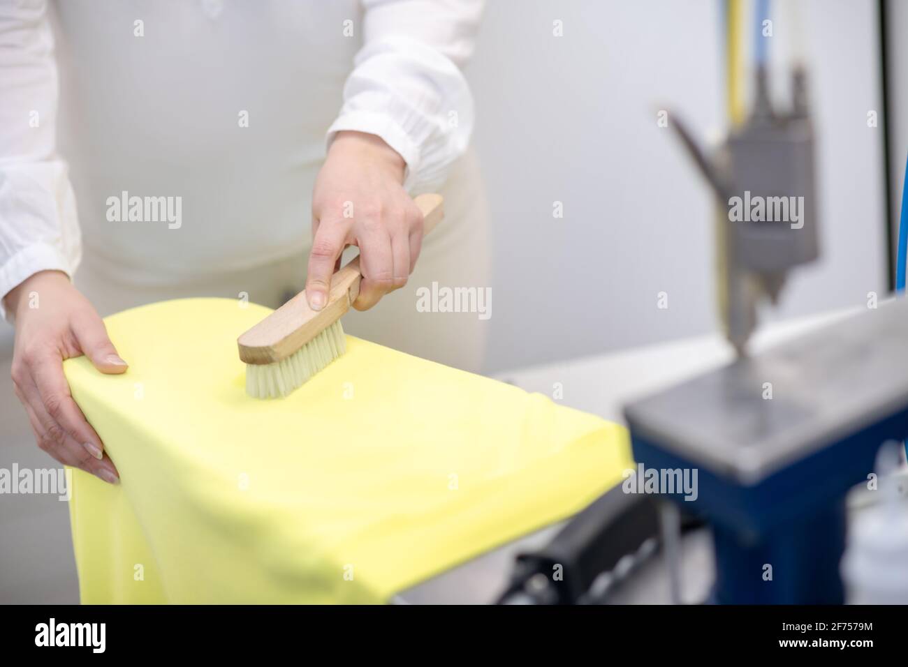 Female hands touching with brush to lying clothes Stock Photo