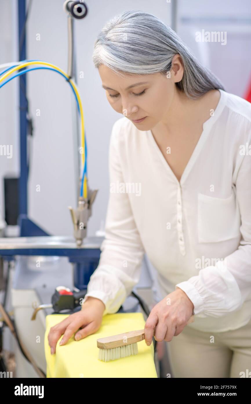 Diligent woman brushing dirty clothes in dry cleaning Stock Photo