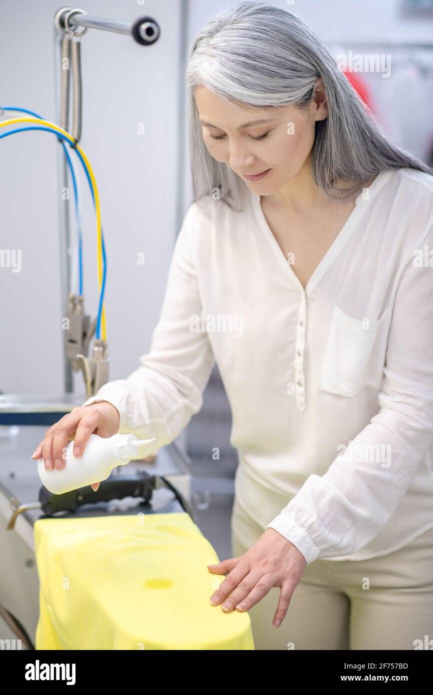 Woman applying stain remover on garment Stock Photo