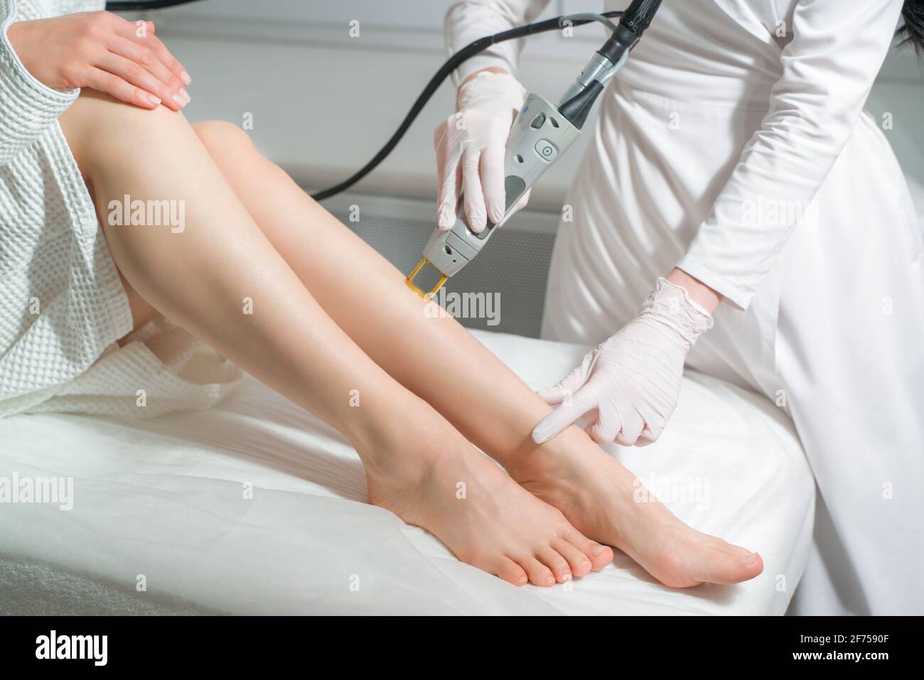 The procedure for removing hair on the body of a woman in a cosmetology clinic. Laser hair removal. Stock Photo