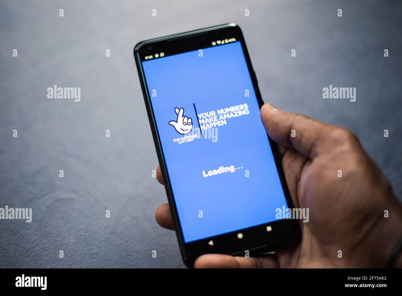 Lotto lottery application on a smartphone held by adult asian man Stock Photo