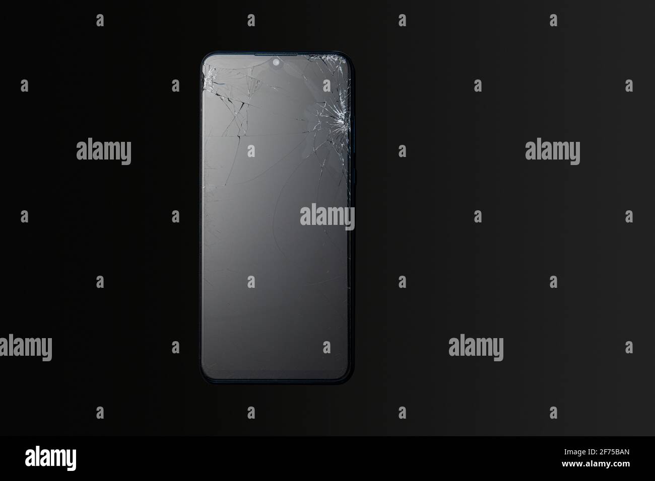 Modern touchscreen smartphone with broken screen on dark background Stock Photo