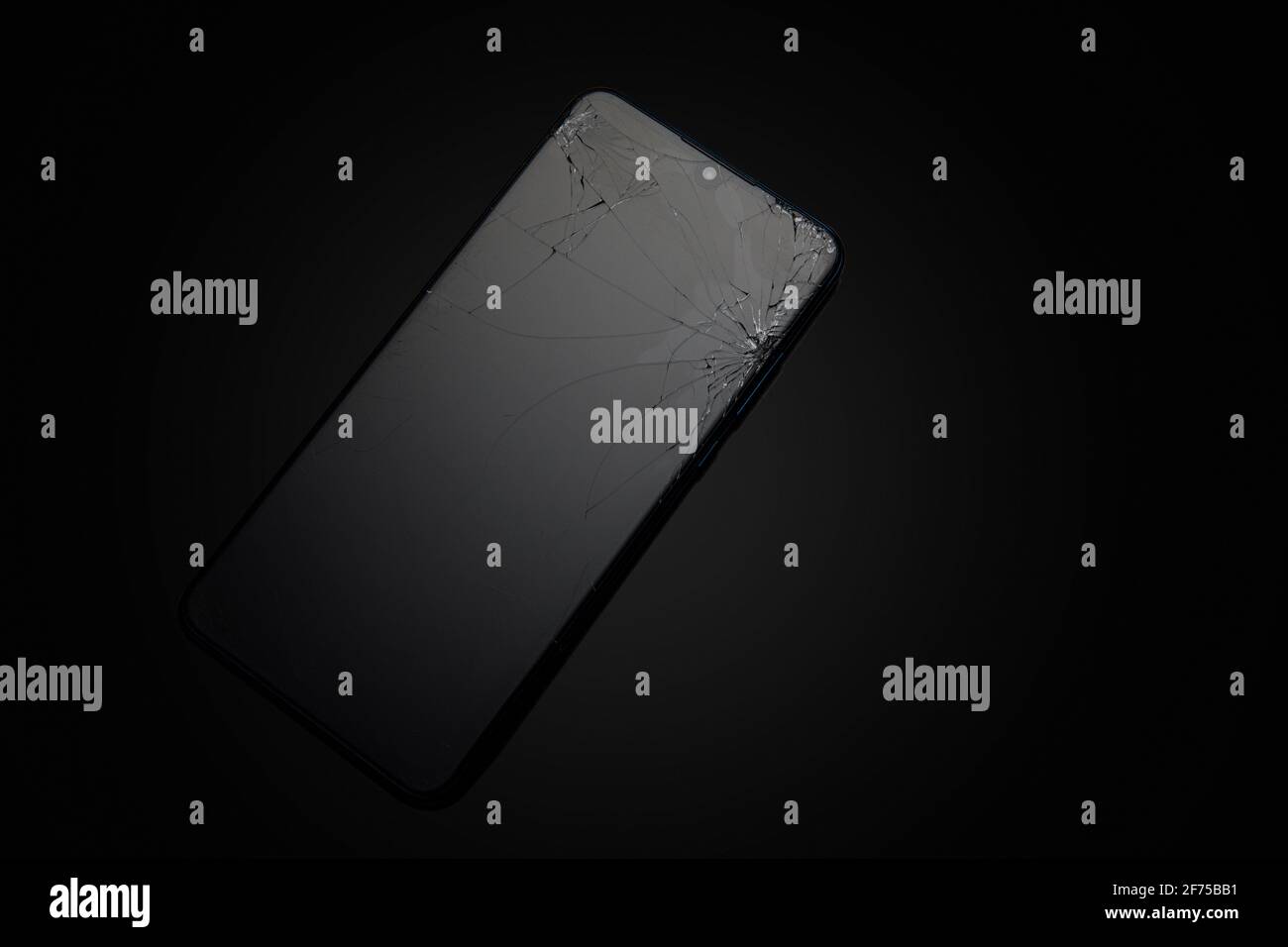 Modern touchscreen smartphone with broken screen on dark background Stock Photo