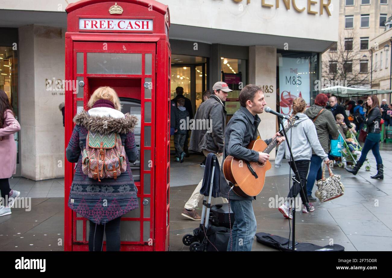 A guitarist performs amongst shoppers in Stall Street, Bath, England, UK Stock Photo