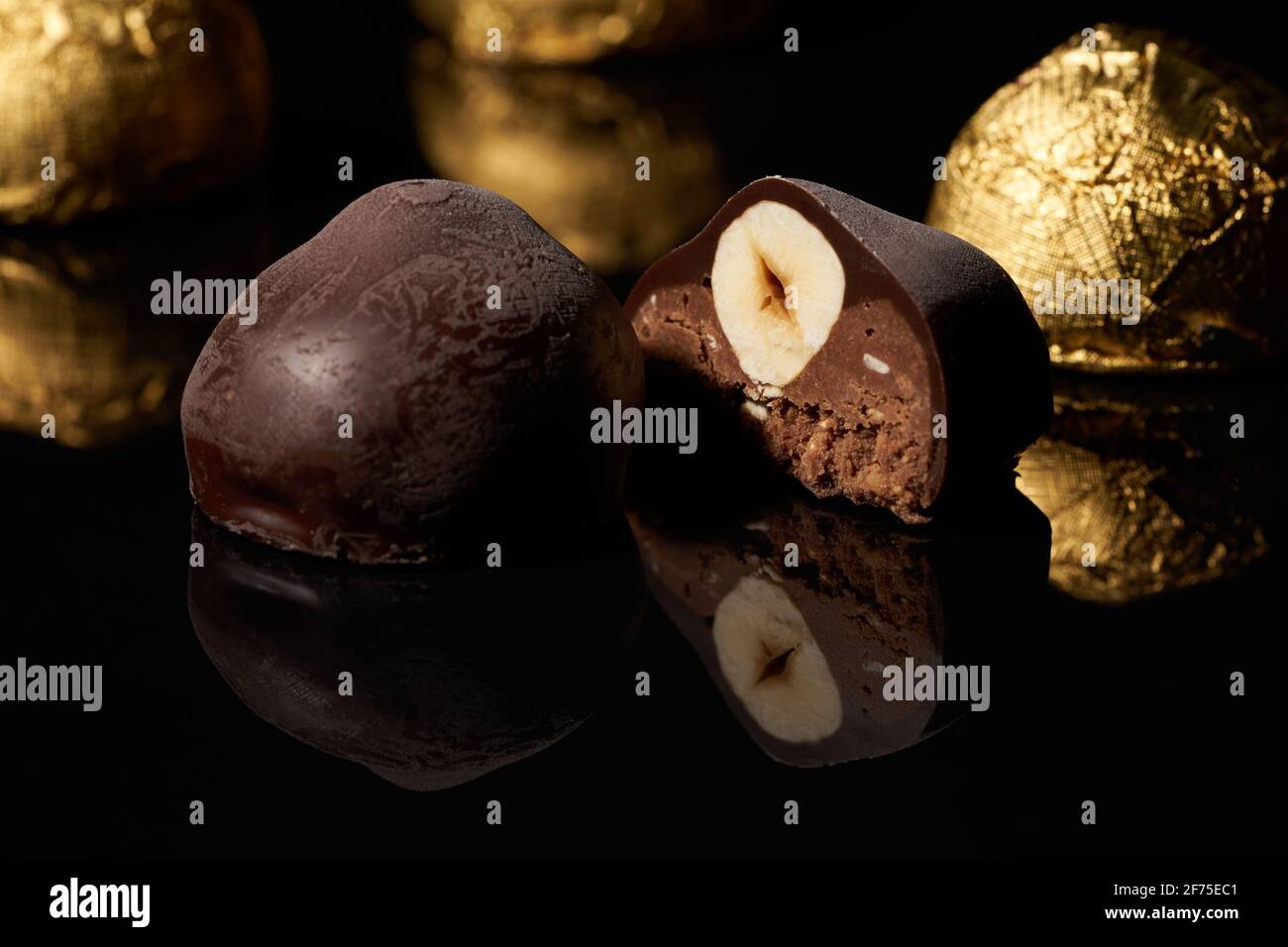 Free Photo  Side view chocolate candy in a gold wrapper on black