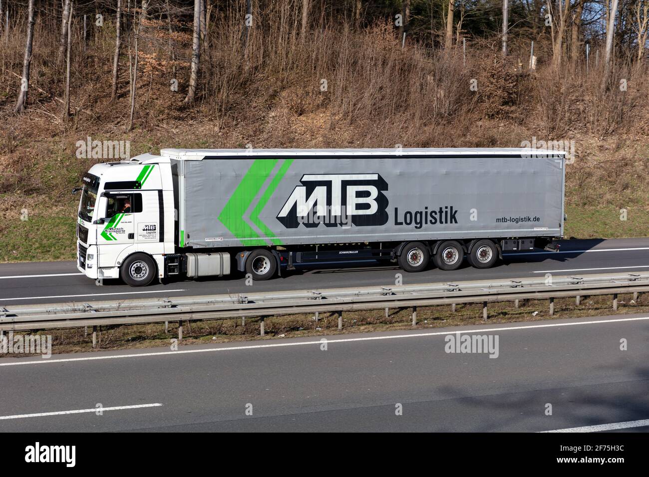 MTB Logistic MAN TGX truck with curtainside trailer on motorway. Stock Photo