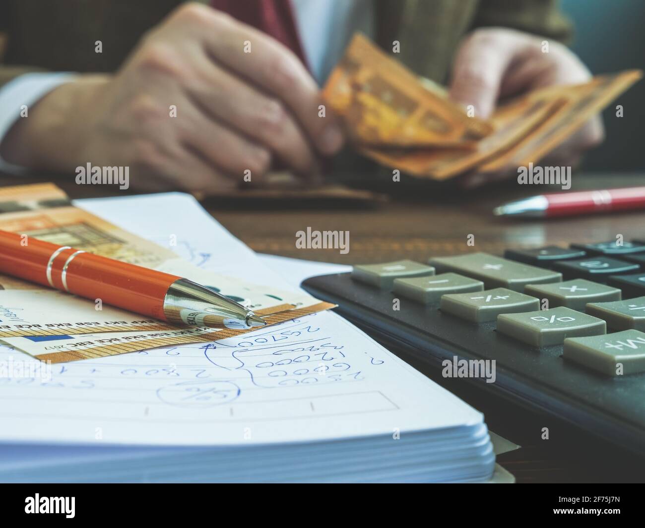 Hands count euro banknotes with calculator and notepad. Stock Photo