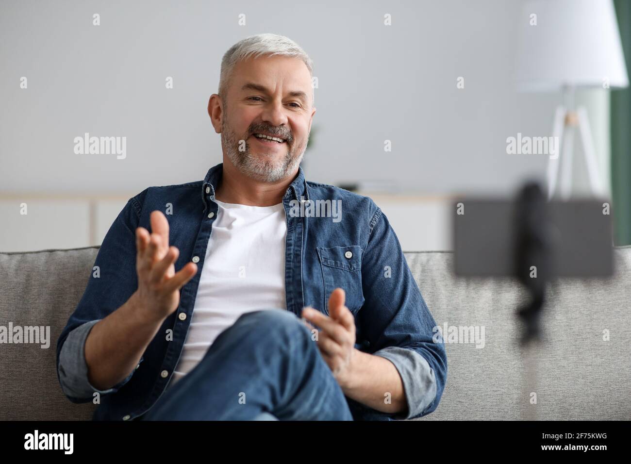 Happy handsome senior man broadcasting from home Stock Photo