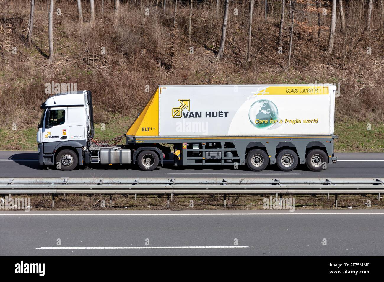 Emons Mercedes-Benz truck with Van Huet glass inloader trailer on motorway. Stock Photo