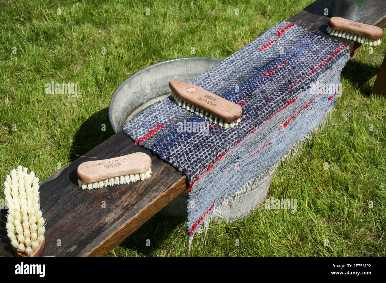 WASHING CARPETS outdoor in the sun with rooth brush and wash sink bowl