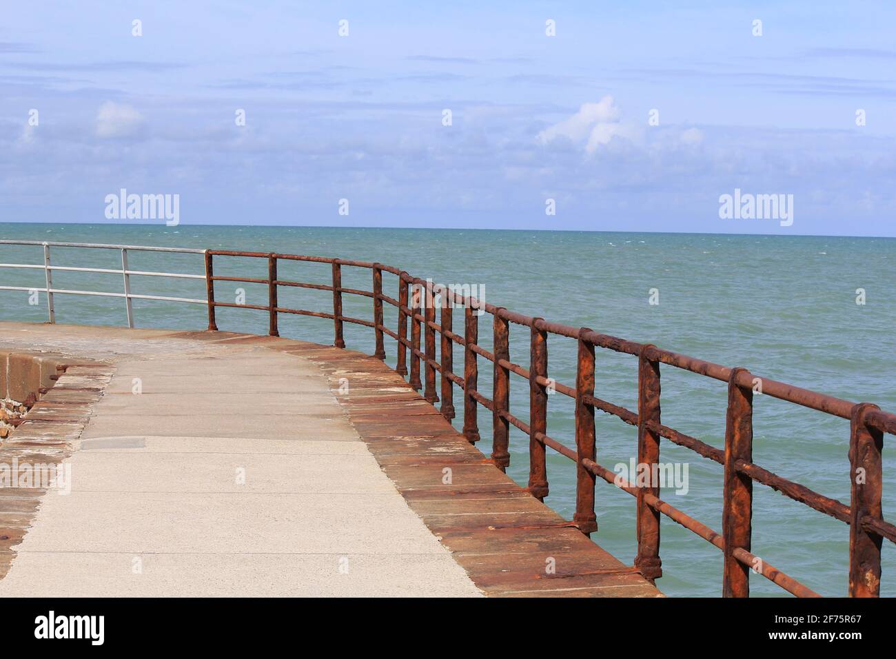 the pier at the french coast in saint-valery-en-caux in normandy and the sea, horizon and blue sky in the background in summer Stock Photo