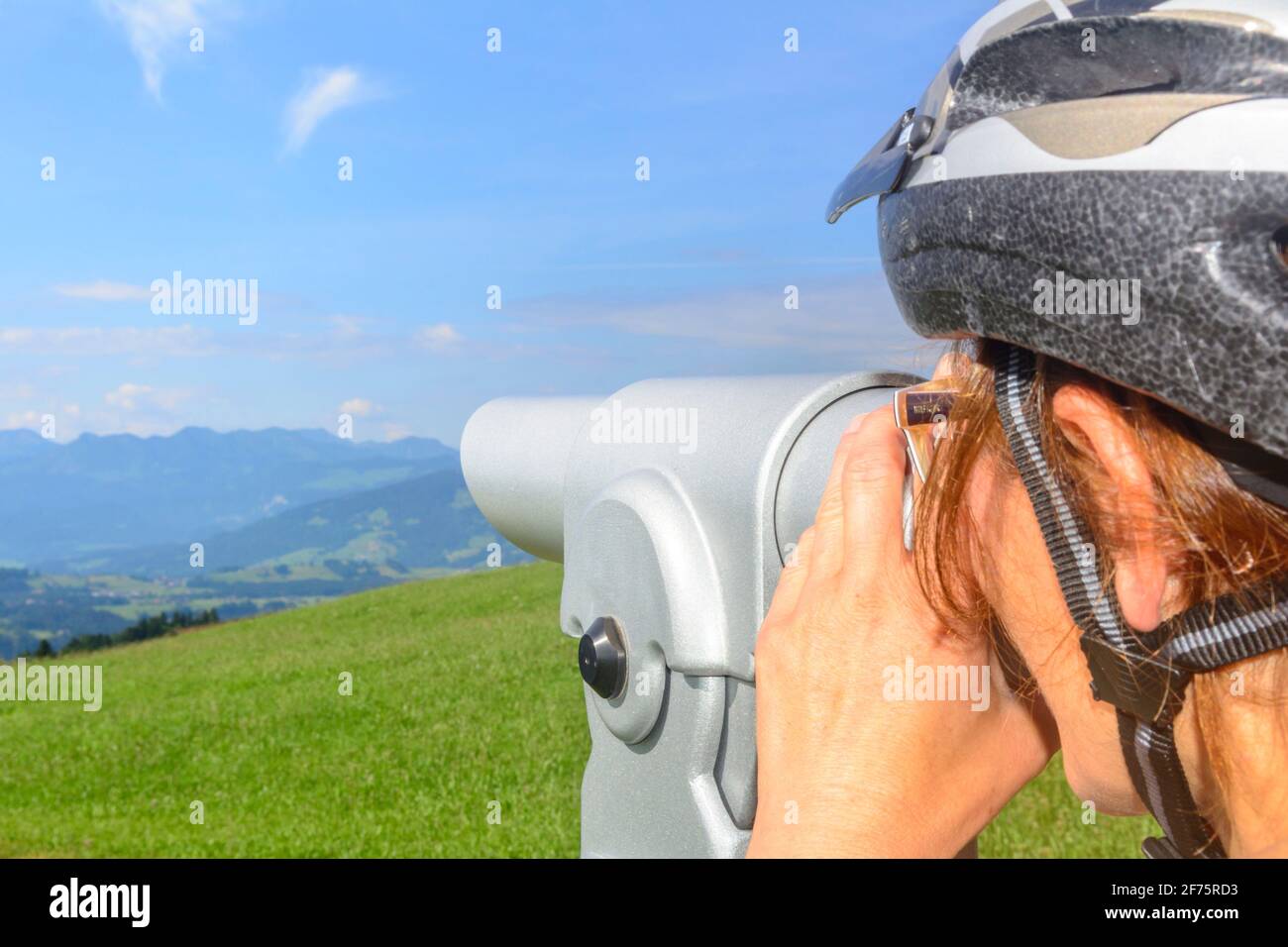Cyclists enjoying the beautiful landscape through telescope Stock Photo