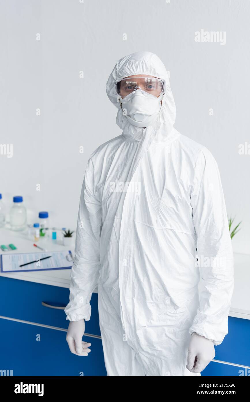 Scientist in hazmat suit and goggles looking at camera in laboratory ...